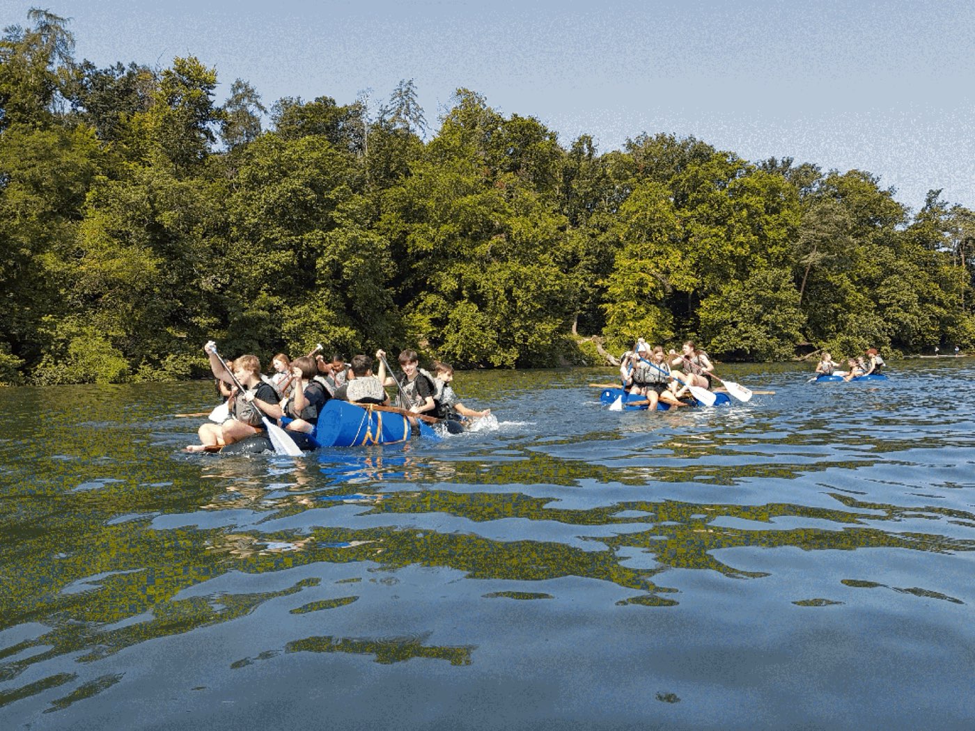 Flossbau-Action auf dem Wasser, Schulklasse in voller Fahrt
